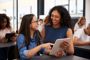 teacher showing something on the tablet to a student