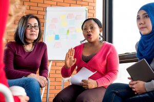diverse group of women discussing an issue, sitting in circle