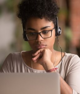 teenager reading on a laptop, focusing