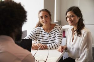 three women having a discussion in an office
