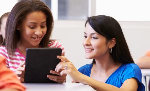 female teacher helping a teenage girl in a classroom